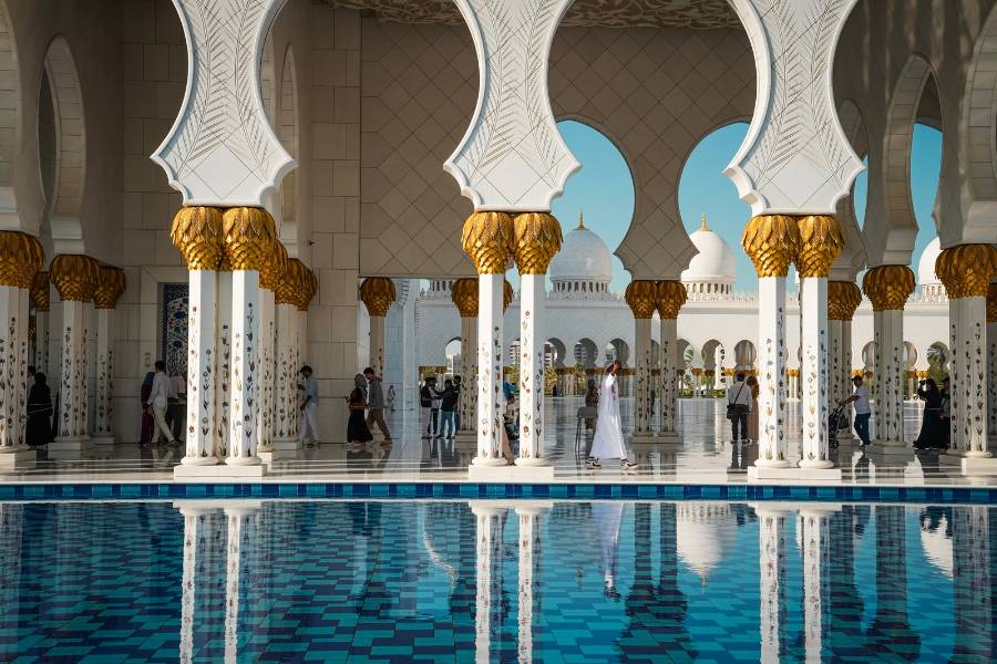 Gold-capped columns reflected in a pool at Sheikh Zayed Grand Mosque